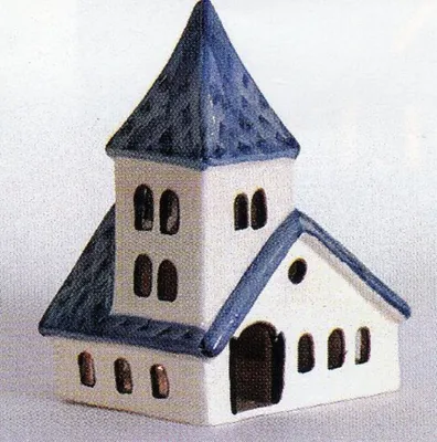 Ein Porzellan Modell einer Romanischen Kirche mit einem hohen, dunkelblauen Dach und weißer Fassade.