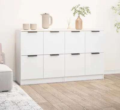 A white sideboard with two rows of cabinets is shown in a room with wooden flooring.