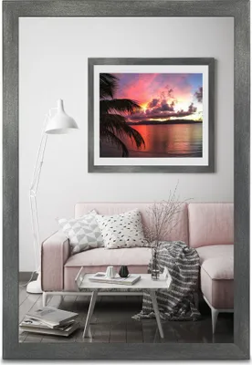 A living room scene with a pink sofa, coffee table, and a framed picture on the wall.