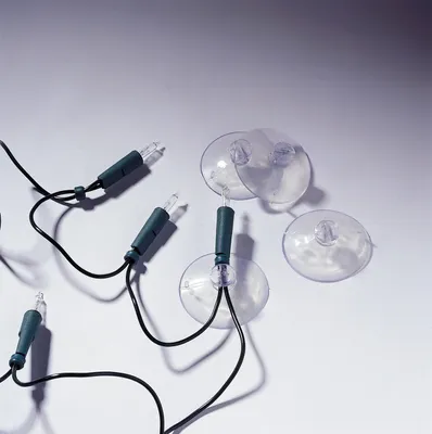 A close-up shot of several suction cups attached to a string of Christmas lights.