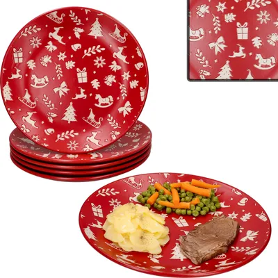 A stack of red Christmas-themed plates and one plate with a Christmas meal on it.