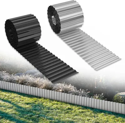 Two rolls of corrugated metal garden edging, one black and one silver, are shown unrolled and installed along a garden bed. The background depicts a garden with grass, plants, and a hint of a fence or structure.
