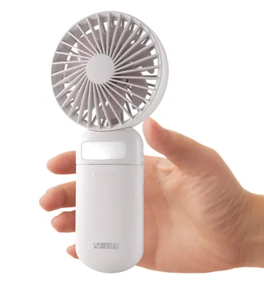 A hand holding a white portable fan.