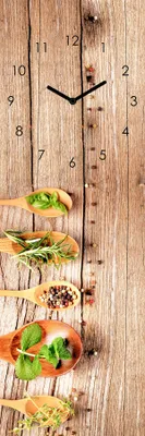 A vertical clock with a wooden background, featuring spoons filled with herbs and spices.