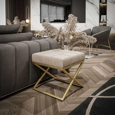 A modern living room with a sofa, ottoman, and chair.