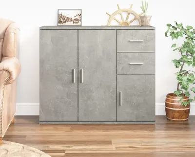 A gray sideboard with two doors and three drawers is shown in a room with a couch and a plant.