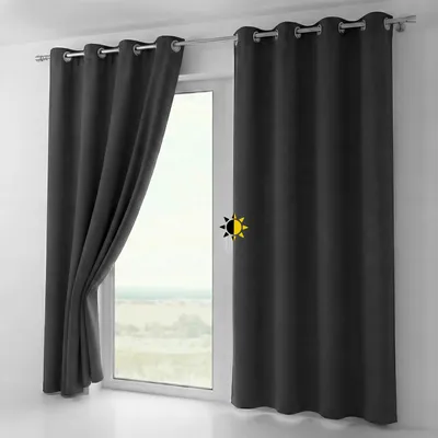 A dark gray blackout curtain is shown hanging on a window rod, with one panel partially open.