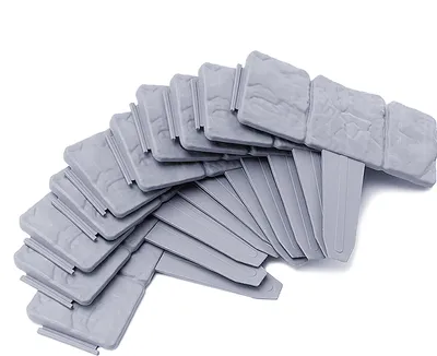 A pile of gray plastic garden edging pieces arranged in a fan shape on a white background.