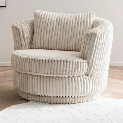 A cream-colored corduroy armchair is shown in a room with a wooden floor and a white rug.