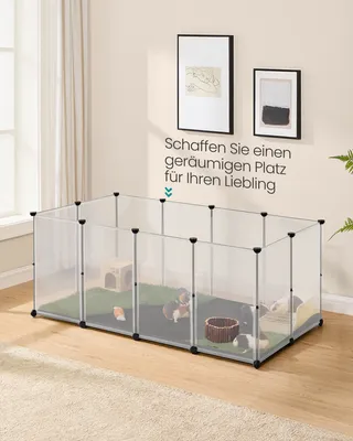 A small animal enclosure with guinea pigs inside, set up in a room with a carpet and wooden floor.