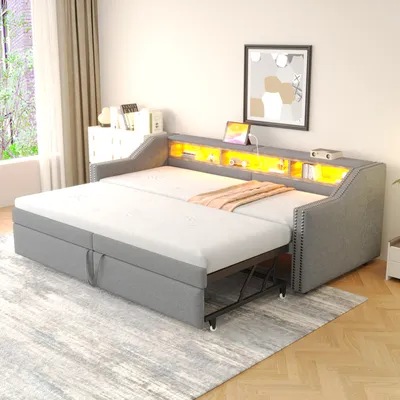 A grey sofa bed is shown in a room with a window and a dresser.