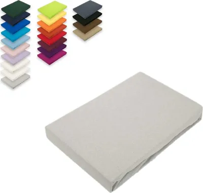 A stack of colorful fabric swatches is shown in the upper left corner, with a single light gray fitted sheet in the foreground.
