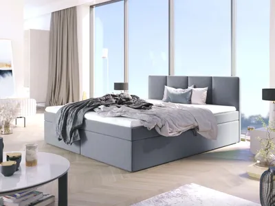 A bedroom with a large bed in front of a window.
