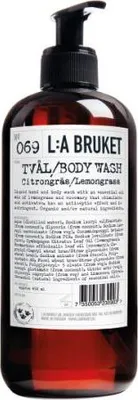 A brown glass bottle of L:A BRUKET body wash with a black pump dispenser.