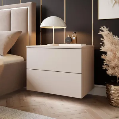 A modern bedroom scene featuring a bedside table with a lamp and decorative items.