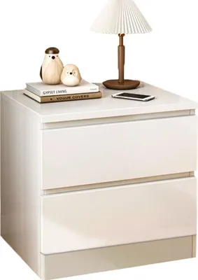 A white nightstand with two drawers is shown with decorative items on top.