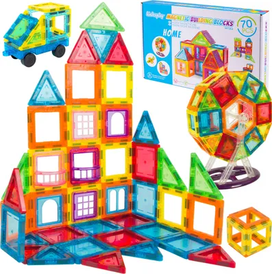 A collection of magnetic building blocks arranged to form various structures, including a house, a Ferris wheel, and a vehicle, with a product box in the background.