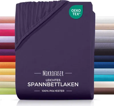 A folded purple fitted sheet is shown, with a stack of other colored sheets in the background.