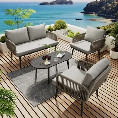 A patio furniture set on a wooden deck overlooking the ocean.