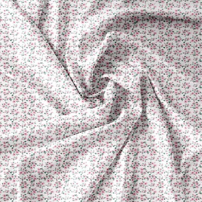 A close-up, top-down view of a white fabric with a small pink and green floral pattern.