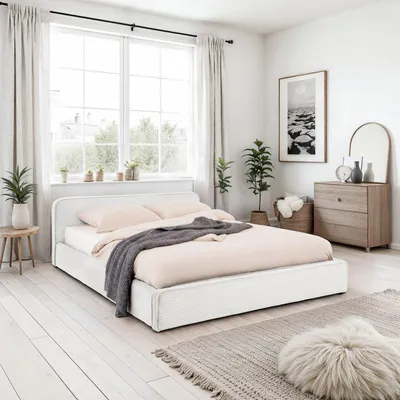 A bedroom scene featuring a white upholstered bed with a gray throw blanket and pink bedding, next to a window with sheer curtains. A wooden dresser and a decorative mirror are visible in the background.