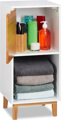 A white bathroom cabinet with a wooden accent door, filled with toiletries and folded towels.