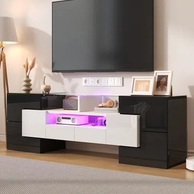 A modern TV stand with LED lighting, featuring a black and white high-gloss finish, is set up in a living room environment.