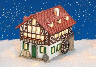 A miniature porcelain mill house illuminated from within, set in a snowy landscape under a starry night sky.