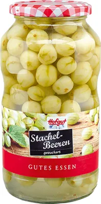 A glass jar filled with preserved gooseberries, with a label on the front.