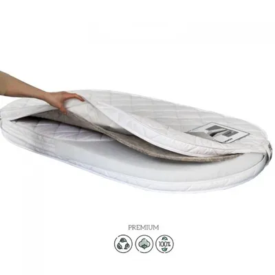 A hand is shown adjusting a mattress cover on an oval mattress.
