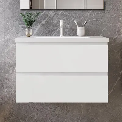 A white bathroom vanity with two drawers set against a marble-like gray wall.