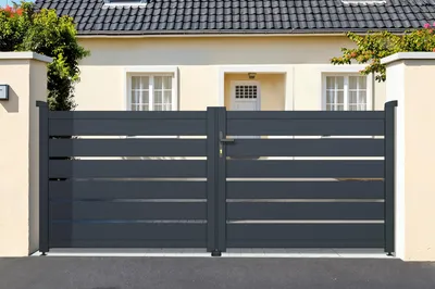 A dark gray double gate in front of a house.