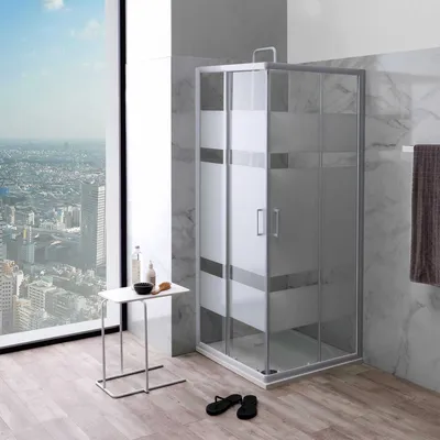A modern bathroom with a corner shower unit, a small side table with toiletries, and a large window overlooking a city.