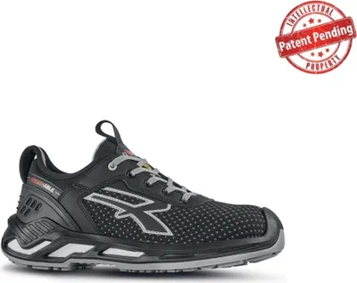 A black safety shoe with gray and white accents, shown from the side against a white background. A red circular stamp with "Patent Pending" is in the upper right corner.