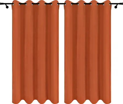 Two orange curtains hanging on a curtain rod against a white background.