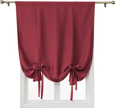 A red tie-up Roman shade hangs on a window.