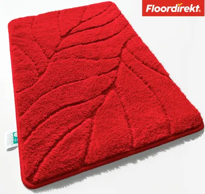 A red bath mat with a leaf-like texture is shown from a diagonal angle on a white background.