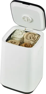 A white towel warmer bucket with its lid open, showing rolled towels inside.