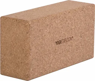 A cork yoga block is shown from a slight angle against a white background.