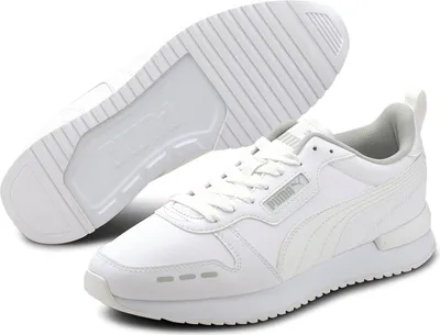 A pair of white Puma R78 SL Runner Uni sneakers are shown from a slightly elevated angle, with one shoe in the foreground and the sole of the other shoe visible behind it.