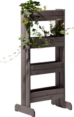 A vertical planter with plants growing on it, set against a white background.