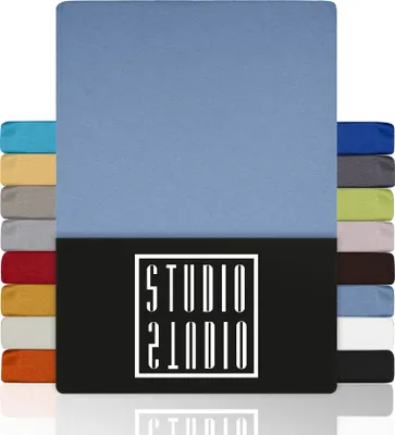 A stack of fabric swatches in various colors, with a large swatch of light blue fabric dominating the top half of the image. A black rectangle with a white logo is in the bottom half.