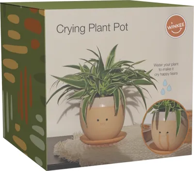The image shows the packaging of a "Crying Plant Pot" with a spider plant in the pot. There is also a smaller inset image showing the pot with water dripping from the eyes.