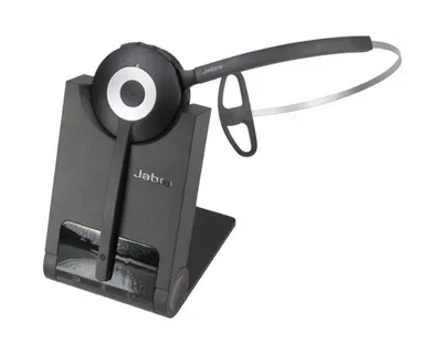 A black Jabra wireless headset is placed on its charging dock.