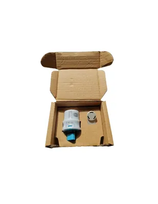 A cardboard box containing a small electronic device and a cap.