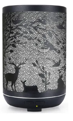 A black aroma diffuser with a decorative cut-out pattern of trees, deer, and birds.