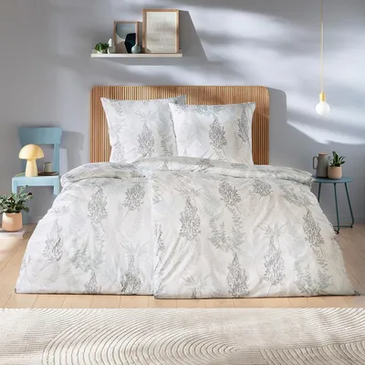 A bedroom scene with a bed, chair, and side table.
