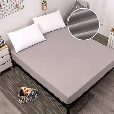 A bed with a grey fitted sheet and two white pillows.