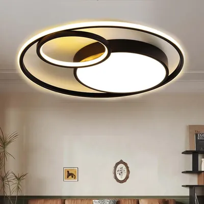 A modern ceiling light fixture with a circular design, illuminated and mounted on a ceiling.