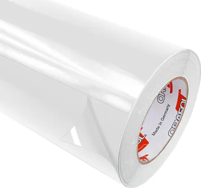 A roll of clear, glossy adhesive film is shown against a white background. The film is partially unrolled, revealing its smooth, reflective surface. The core of the roll, made of cardboard, is visible on the right side, with text and branding printed on it